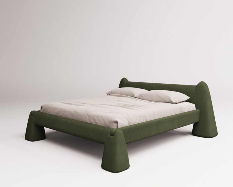 A minimalist green bed with a curved frame and angled legs, featuring a simple beige mattress and pillows on a plain white background