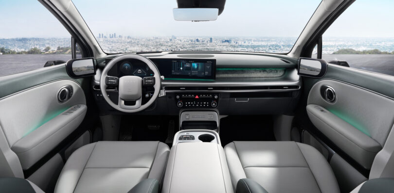 Futuristic car interior with a digital dashboard, modern steering wheel, and white leather seats. City skyline visible through the windshield.