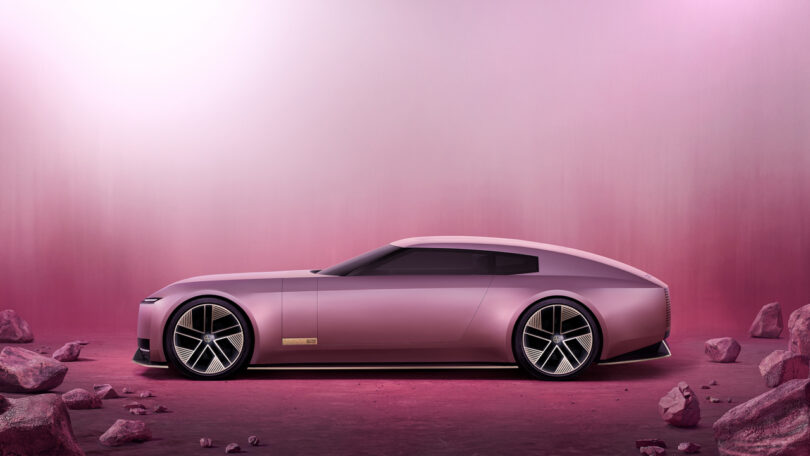 A sleek, futuristic pink car is displayed against a matching pink gradient background, surrounded by scattered pink rocks.