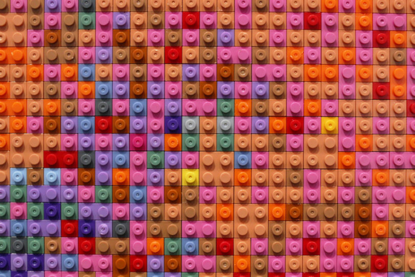 Dozens of colorful toy bricks create pixelated abstraction