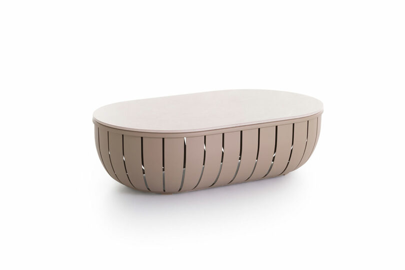 Oval-shaped beige coffee table with a slatted base design, placed on a white background.