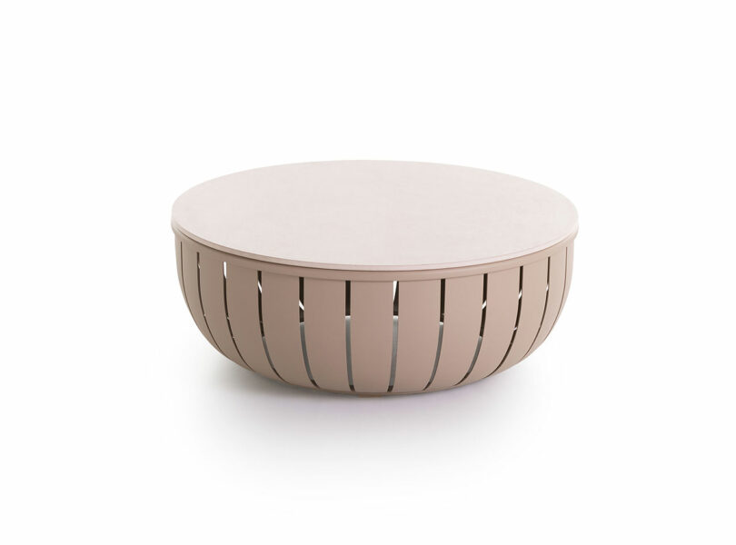 Round, beige coffee table with a smooth top and slatted side design, set against a white background.