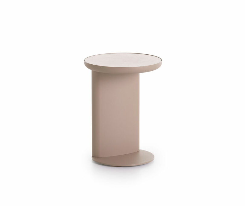 A round, modern side table with a beige finish, featuring a vertical panel support and round base.