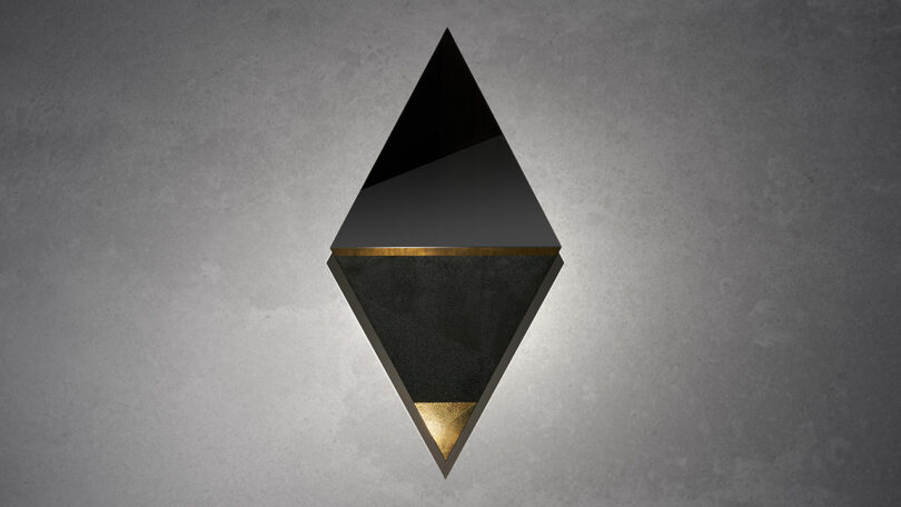 Geometric wall decoration with a diamond shape, featuring black, gold, and dark textures against a gray background.