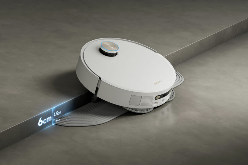 The Dreame X50 robotic vacuum cleaner skillfully navigates over a small step, showcasing its capability to handle obstacles up to 6 cm high.