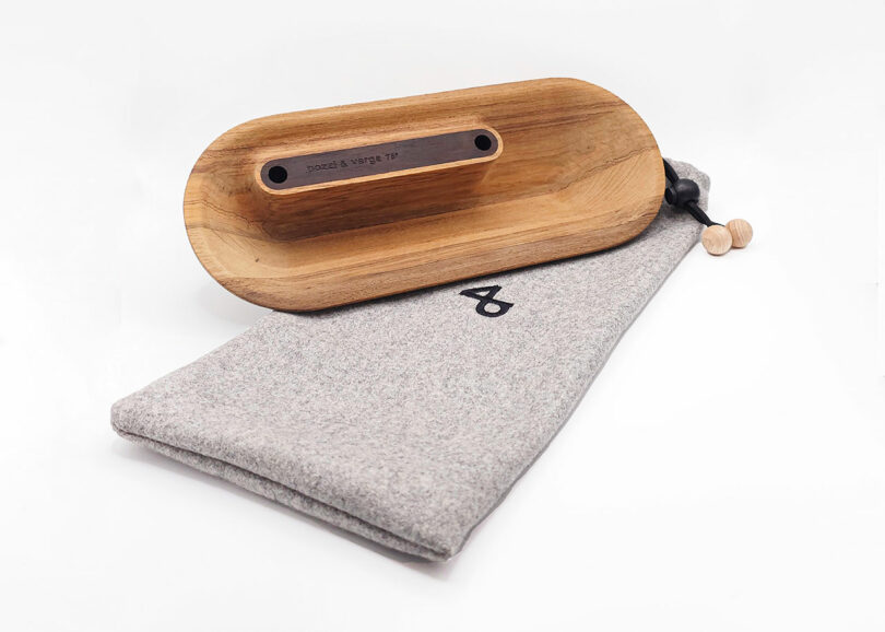 Wooden eyeglass stand atop a gray felt pouch with a drawstring closure.