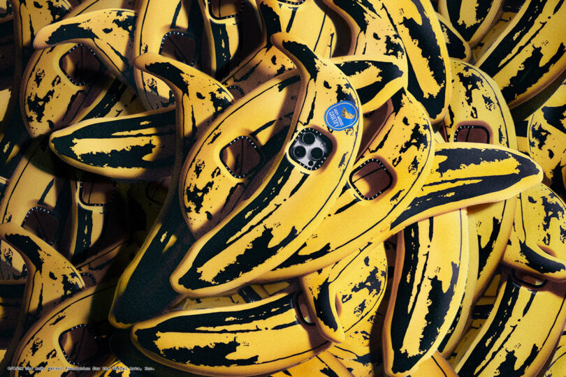 A pile of banana-shaped soft cases, each featuring camera lens cutouts and a small blue sticker.