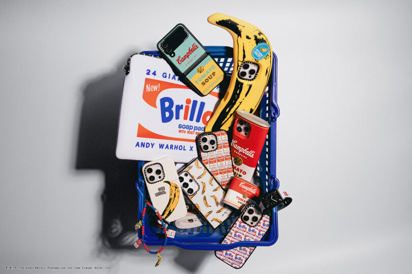 A blue basket containing phone cases, a Campbell's can, a Brillo soap pads box, a banana, and small items, all designed in a pop art style reminiscent of Andy Warhol.