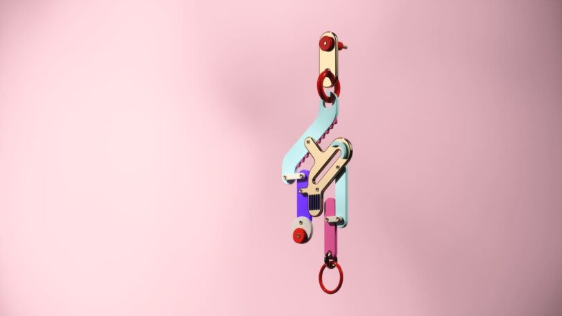 A colorful abstract earring with geometric shapes against a pink background.