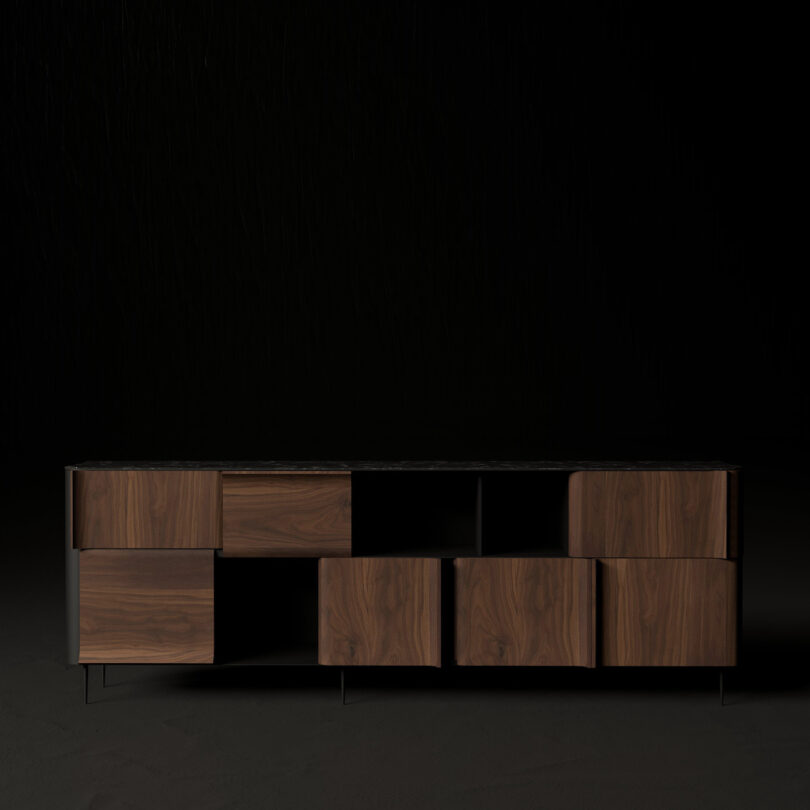 A modern, dark wooden sideboard with a geometric design against a black background