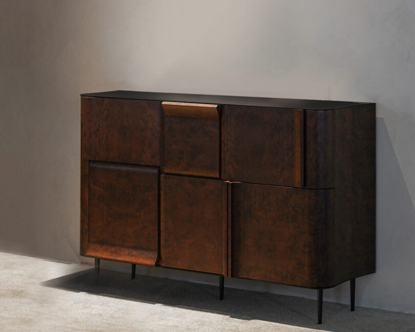 A modern cabinet with a dark wood finish and sleek design, featuring two rows of large, asymmetrical doors