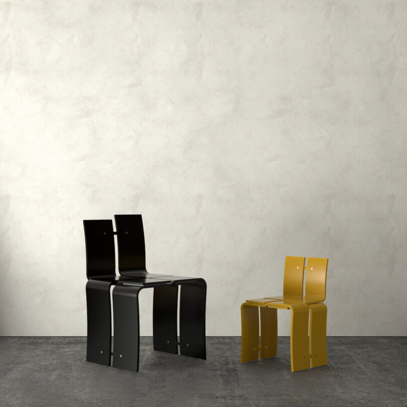 Two modern chairs: one black and larger, one yellow and smaller, against a textured light wall on a dark floor