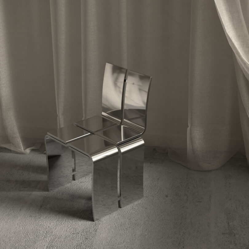 A sleek, modern metallic chair with a reflective surface stands on a textured floor in front of a sheer curtain