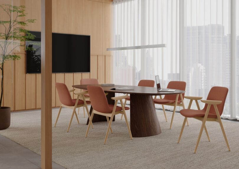 Modern conference room with a wooden table, six orange chairs, large window with city view, and a potted plant