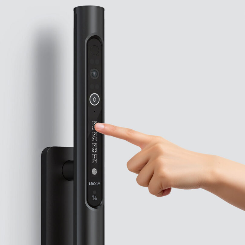 A hand pressing a button on a sleek, black digital door lock with a keypad and doorbell icon.