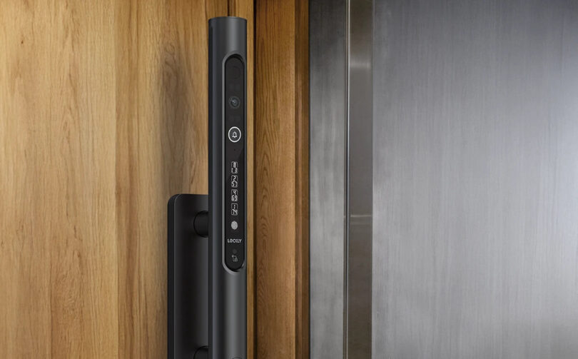 Black smart lock installed on a wooden door next to a metallic doorframe.