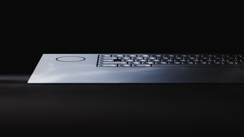 Close-up of a sleek, modern keyboard on a dark background, highlighting a unique circular feature on the left side.