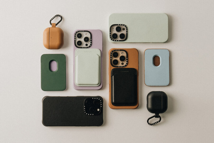 A variety of smartphone and earbud cases in different colors and shapes are arranged on a light surface.