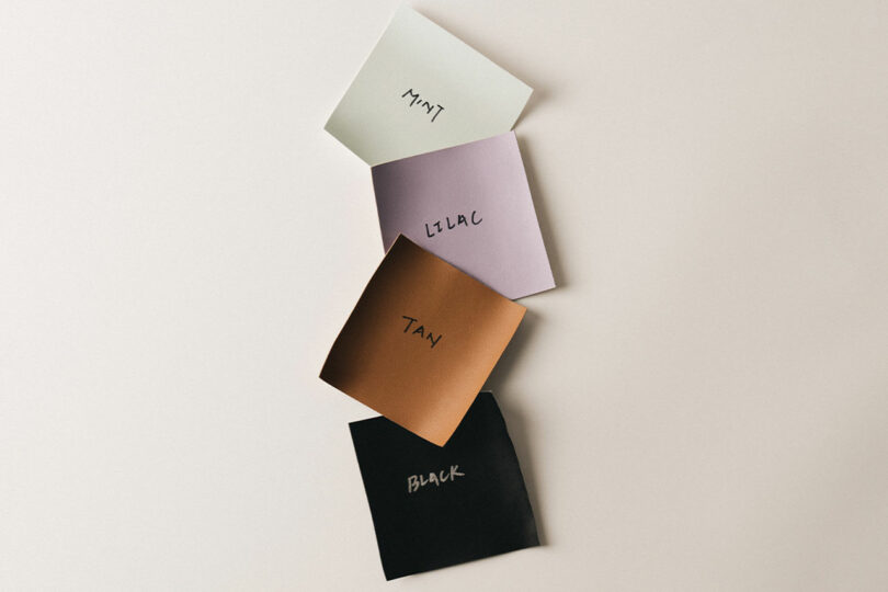 Four paper squares labeled Mint, Lilac, Tan, and Black are arranged vertically on a light background, embodying the sleek design akin to a CASETiFY collection.