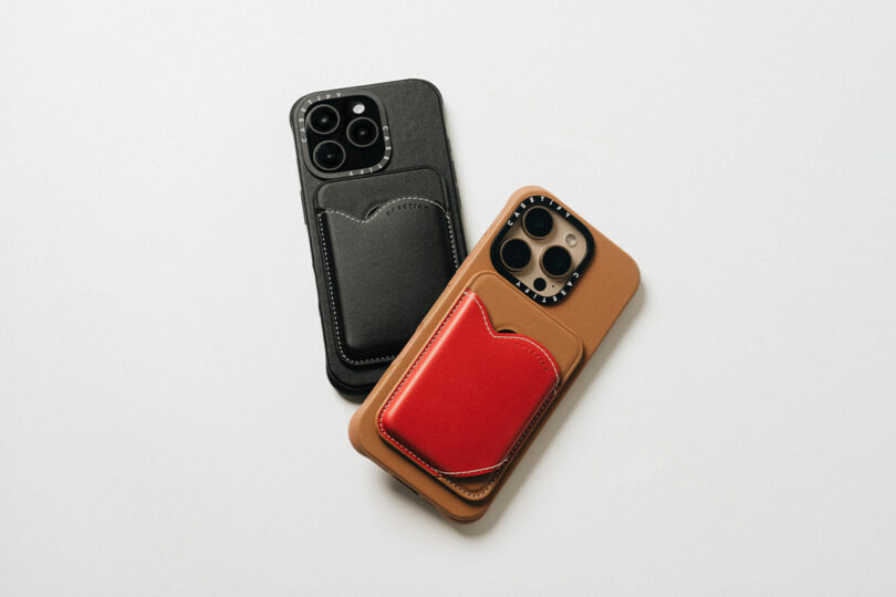 Two smartphones with leather wallet cases, including a stylish CASETiFY design, rest on a white surface. One case is sleek black while the other is tan with a striking red pocket.