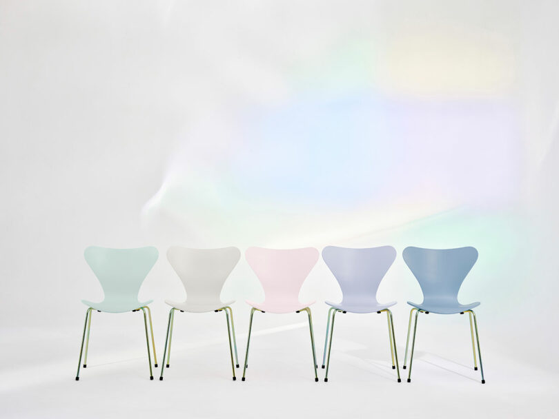 Five pastel-colored chairs in a row on a white background with soft rainbow light effects.