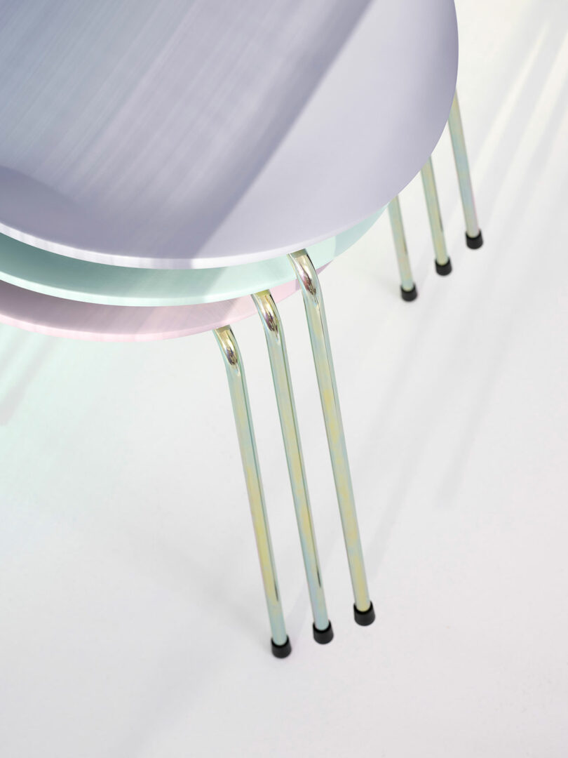 Stacked round tables with metallic legs on a light background.