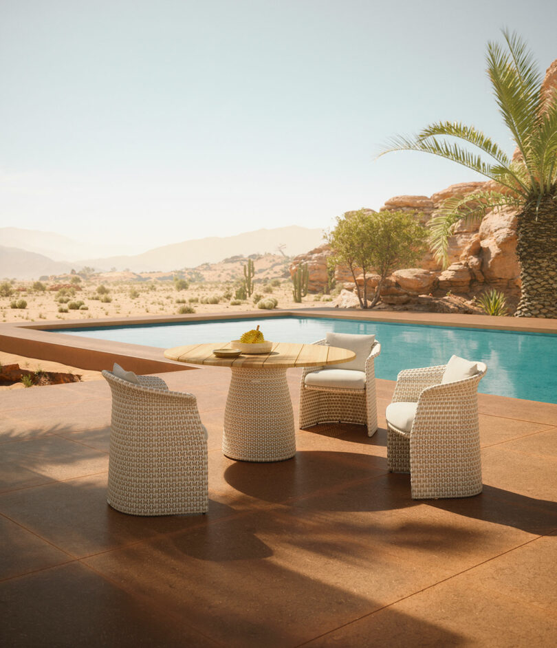 The outdoor patio scene features a DEDON round table and four wicker chairs by a pool, all set against a stunning desert landscape with palm trees and distant mountains under a clear sky.