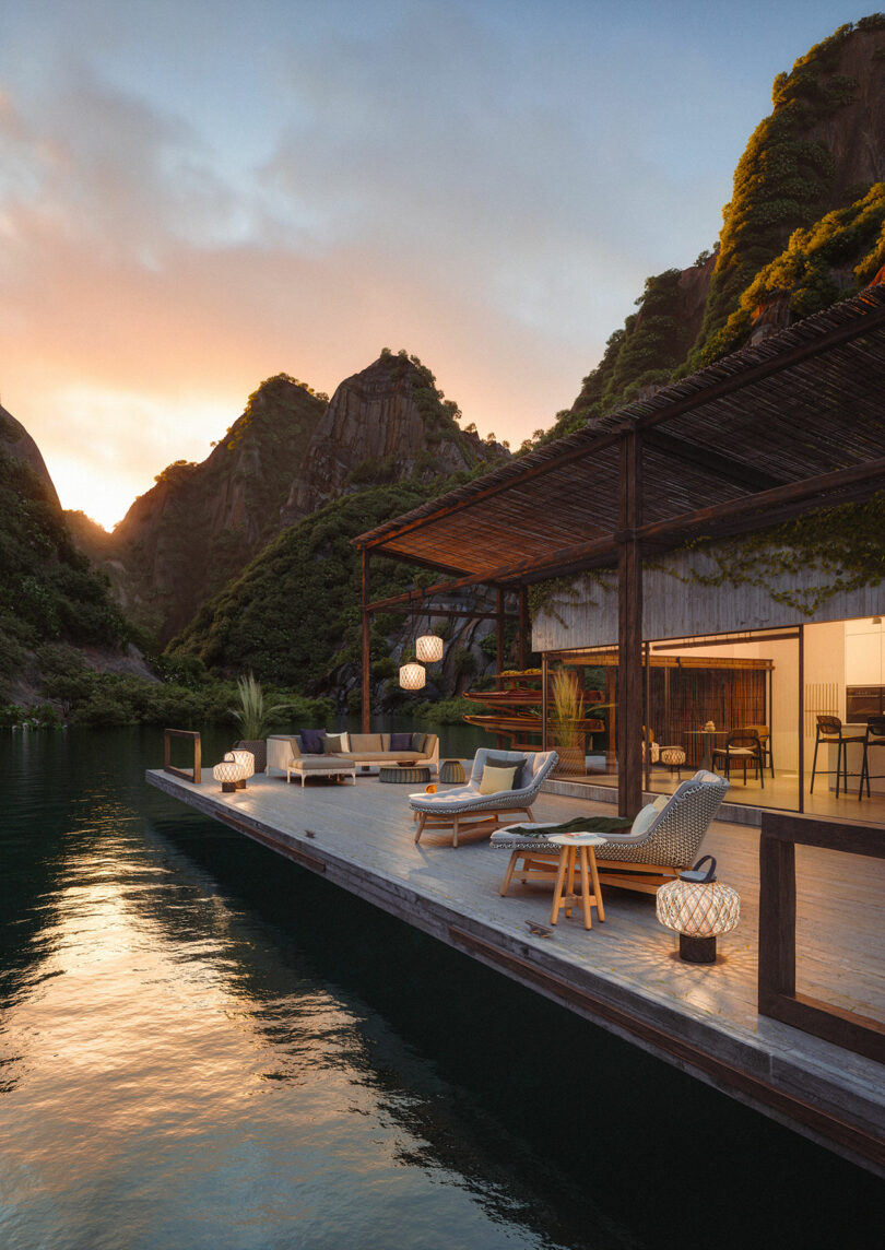 A DEDON floating deck with lounge chairs and a canopy overlooks a serene lake, embraced by lush, rocky hills at sunset.