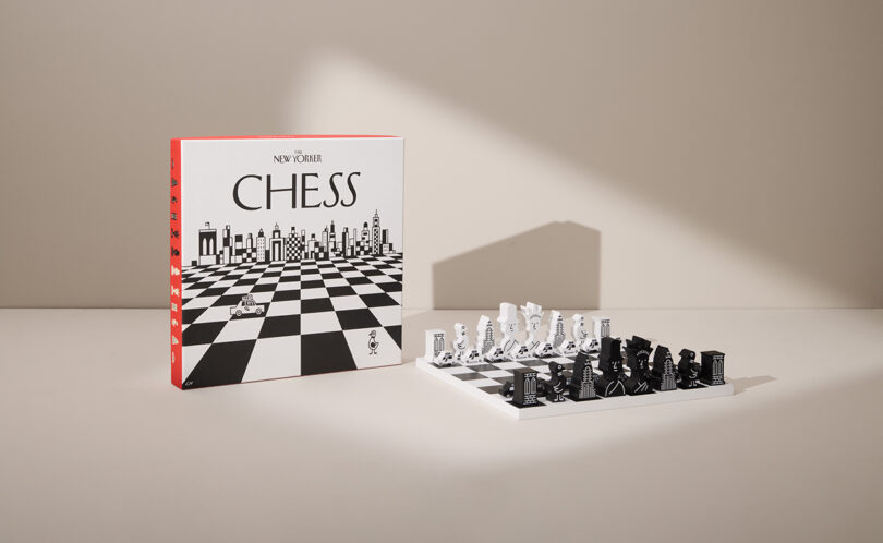 Chess set with black and white pieces arranged on a chessboard. A box labeled "New Yorker Chess" with a black and white pattern is placed standing upright beside the board.