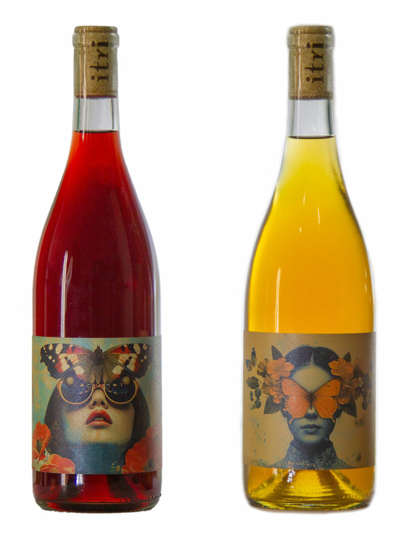 Two wine bottles with artistic labels: the left bottle is dark red and the right bottle is golden yellow. Both labels feature a woman's face with butterfly-themed designs.