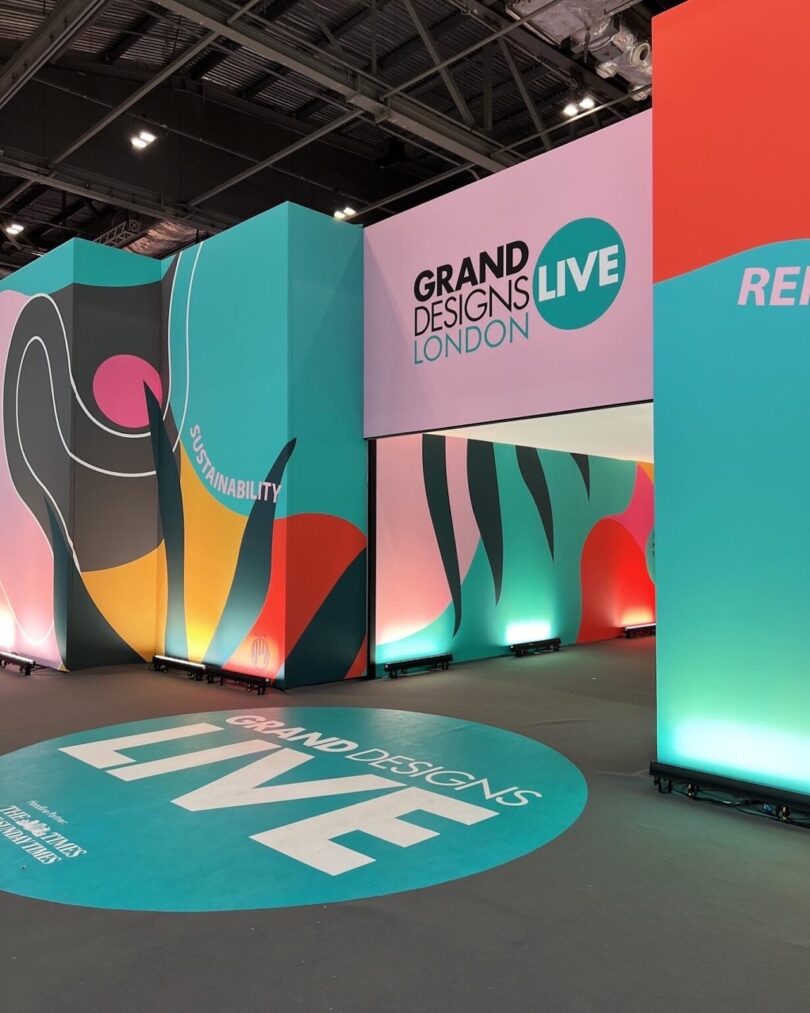 Colorful entrance to Grand Designs Live London event, featuring abstract designs and the word "Sustainability" on one wall