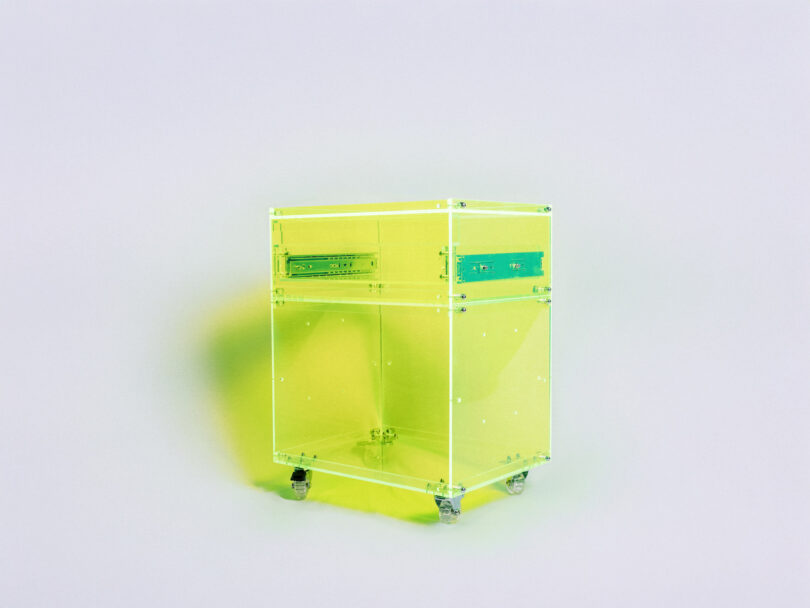 A transparent neon yellow-green cabinet on wheels, with two top handles and visible screws