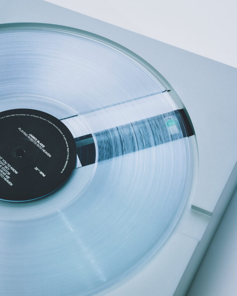 Close-up of a clear vinyl record on a PP-1 turntable, highlighting the black label with white text in the center.