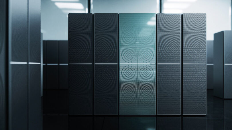 A row of modern, metallic server racks with a sleek, reflective surface in a dimly lit data center.