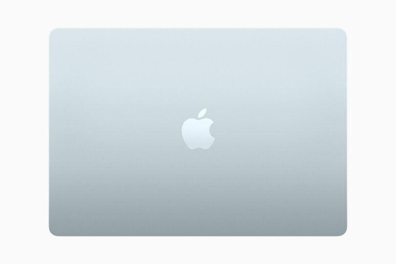 A sleek, closed silver MacBook Air with the iconic Apple logo glimmering on the lid, viewed from above against a pristine white background.