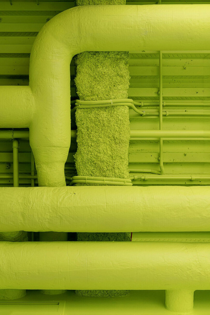 A ceiling with green painted pipes