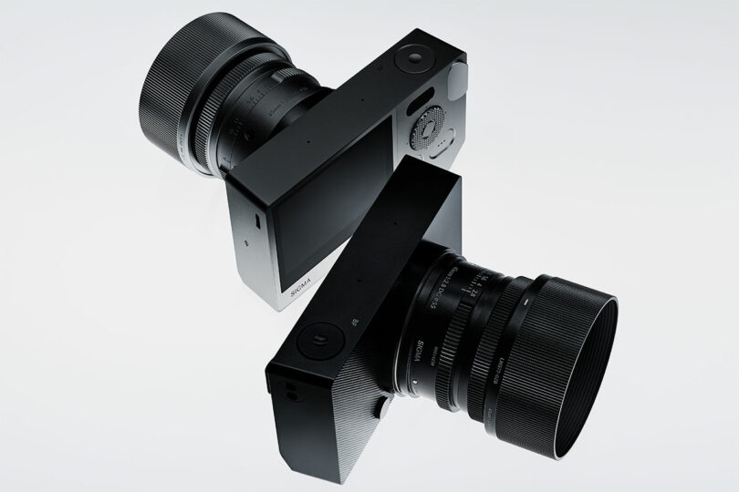 Two modern digital cameras, featuring Sigma BF large lenses, are positioned back-to-back against a neutral background.