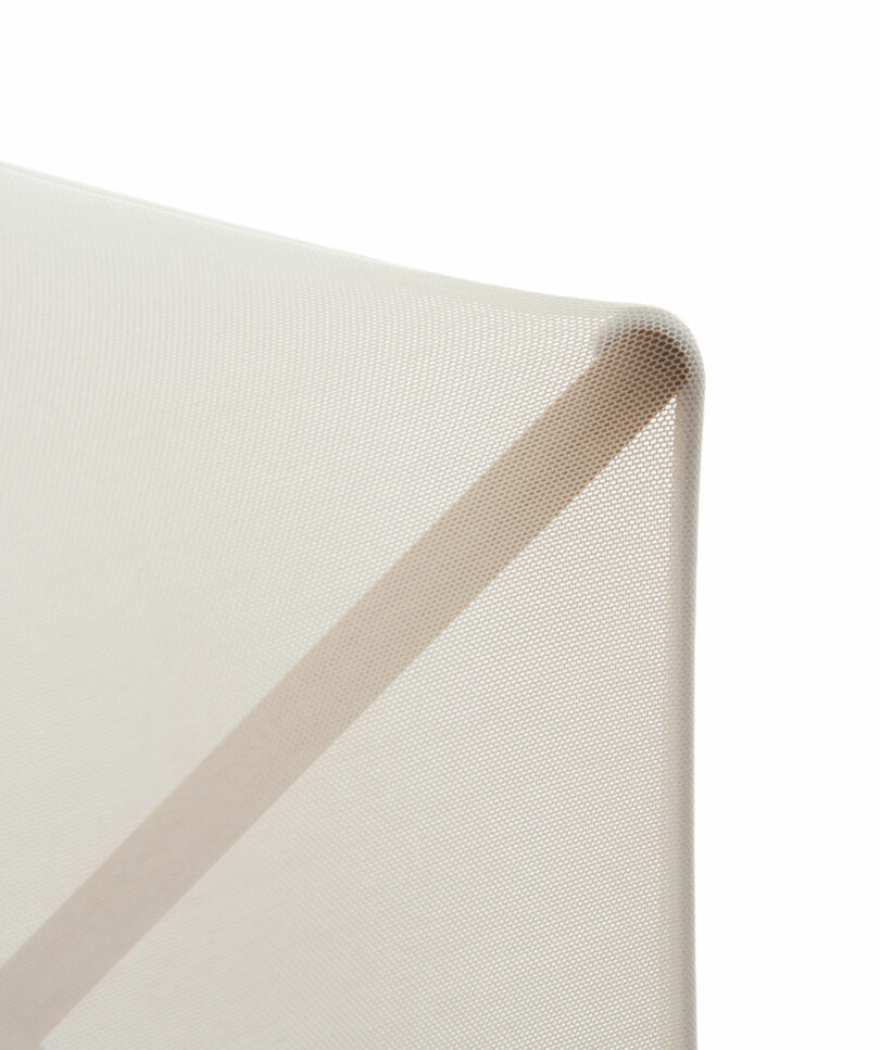 Close-up of a light beige, textured fabric stretched tightly over a frame, showcasing Samuel Wilkinson's minimalistic design and neutral color palette.