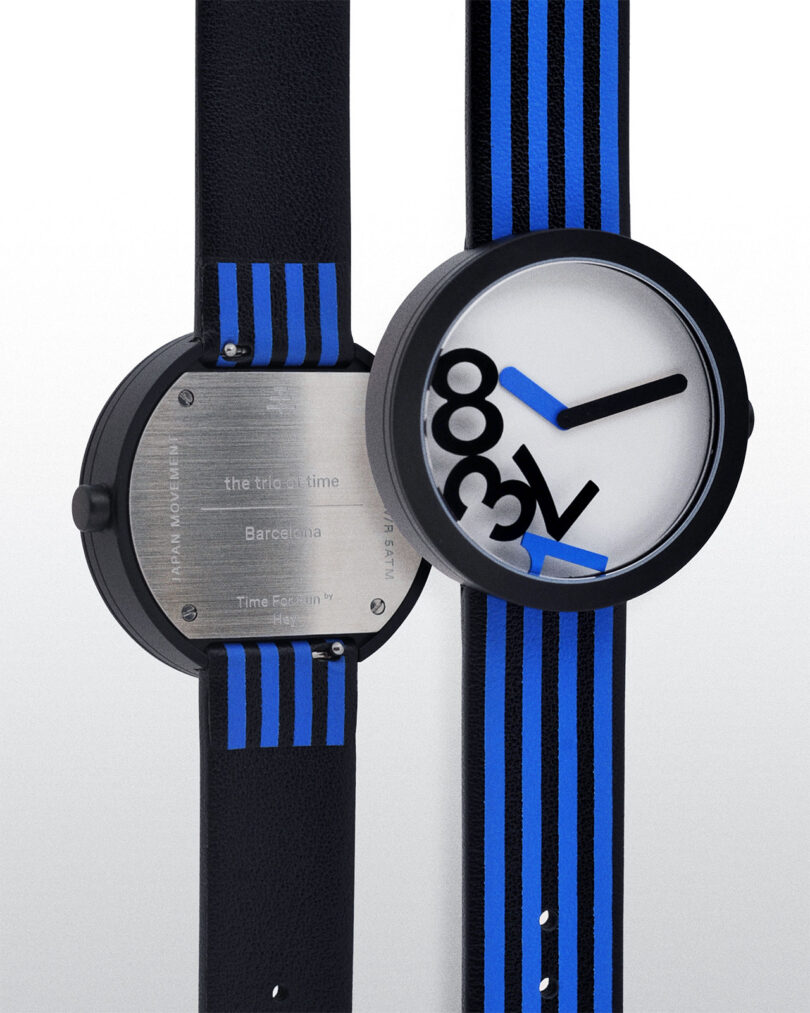 Two black watches with blue-striped bands. One shows the back with engraved details; the other displays a white face with bold 3, 6, 9, 12 numbers and blue hands.