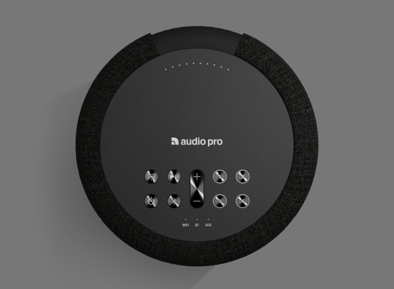 Top view of a black cylindrical audio device with control buttons, labeled "audio pro," on a gray background.