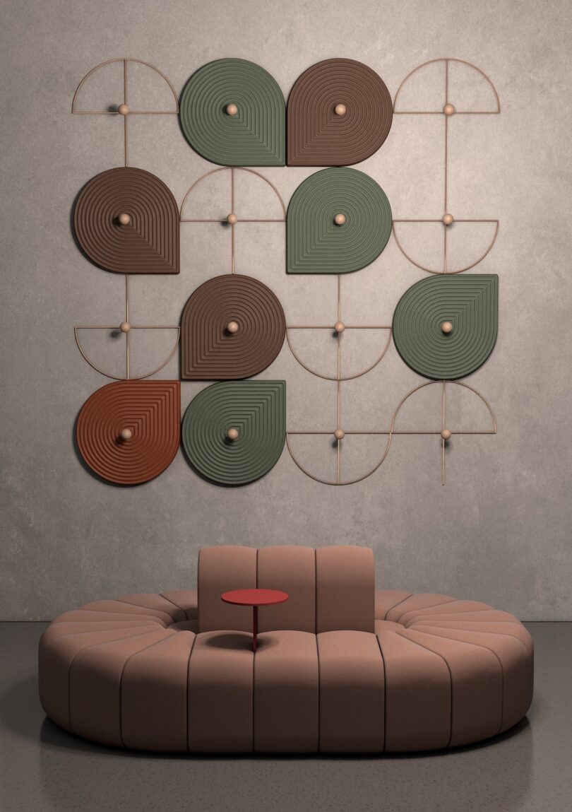Sculptural wall art with geometric patterns and earth tones above a curved, beige sofa 