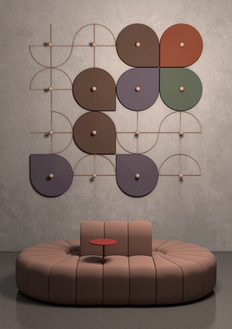 Sculptural wall art with geometric patterns and earth tones above a curved, beige sofa 