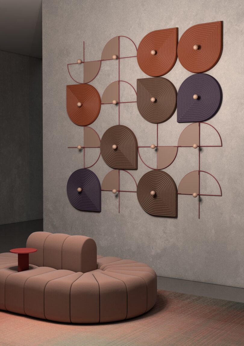Modern interior with a curved beige sofa and a geometric wall art piece featuring circular and semi-circular patterns in shades of brown and purple