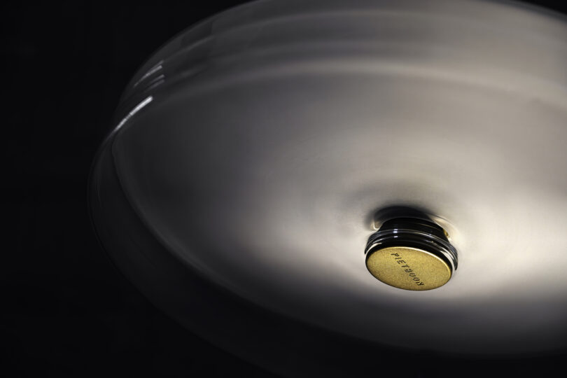 Close-up view of an illuminated ceiling light fixture with a central golden element