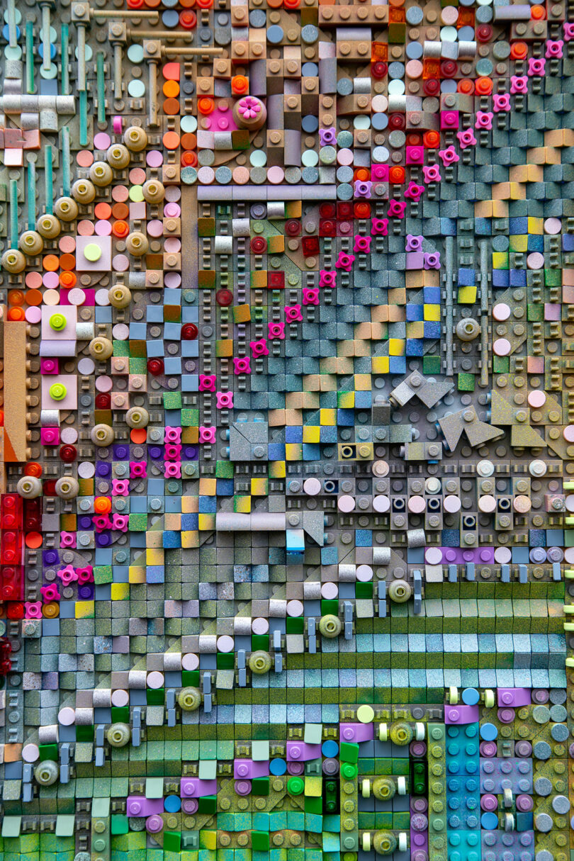 A close-up of an abstract mosaic by Katherine Duclos, made from colorful LEGO bricks arranged in a geometric, pixelated pattern with various shapes and textures.
