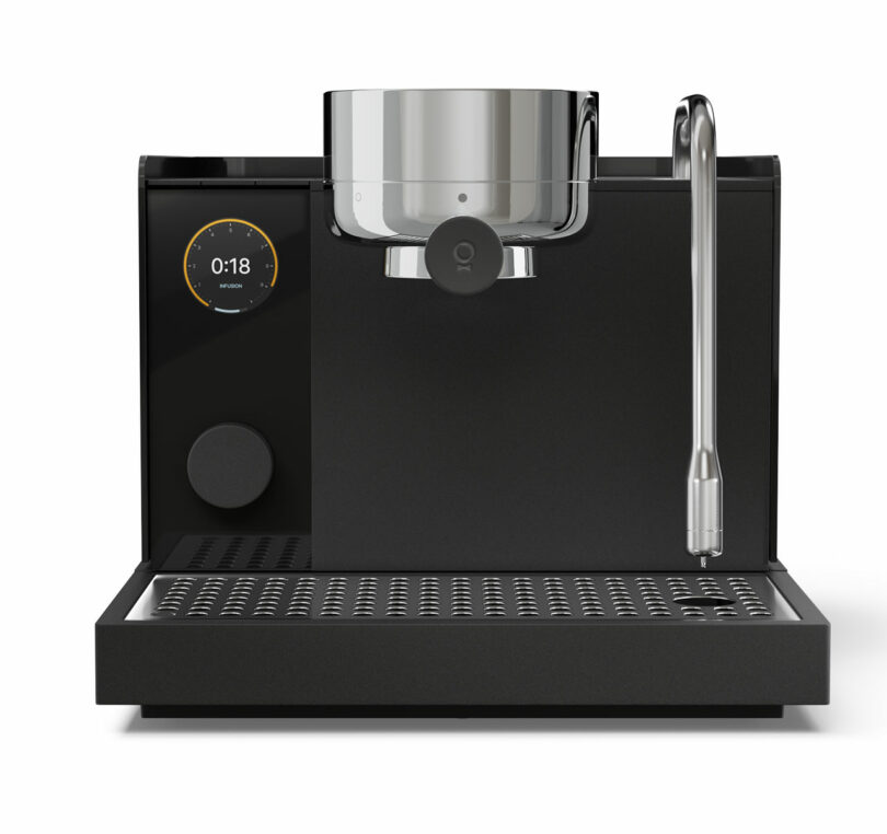 A modern black Fellow espresso machine with a digital timer display, a large metal cup holder, and a steam wand on the right side.