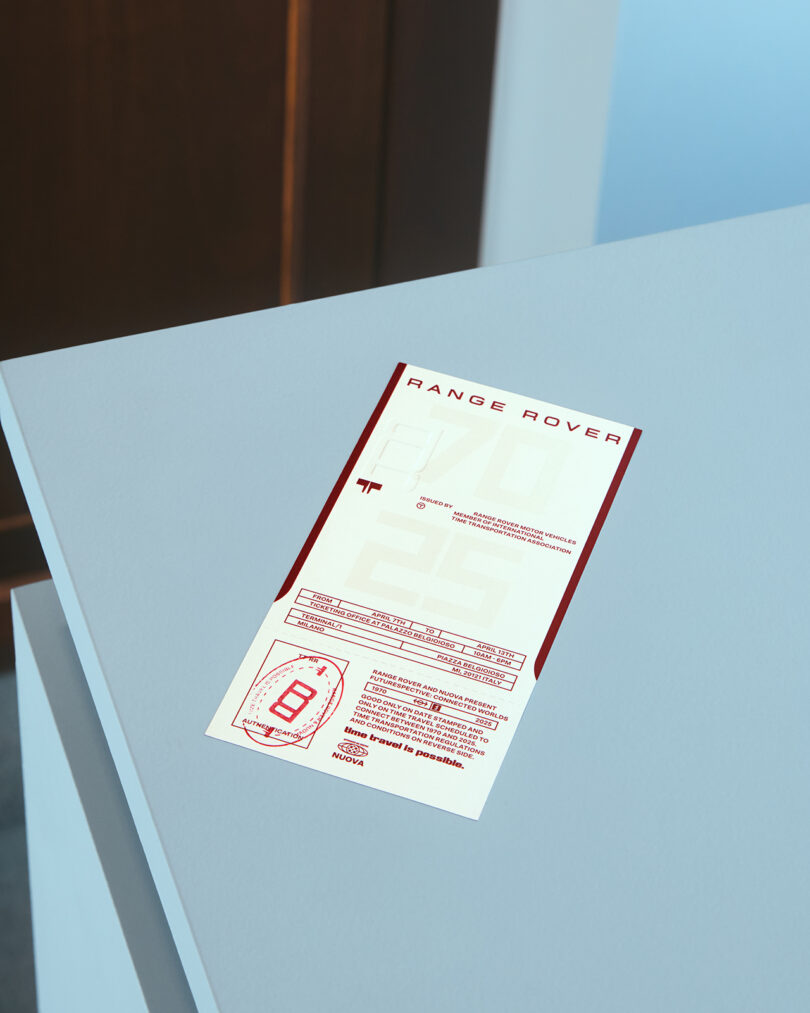 A printed Range Rover information sheet with red text and graphics lies on a light blue surface near the edge of a desk.