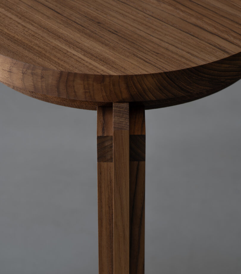 Close-up of a wooden round tabletop with legs. 
