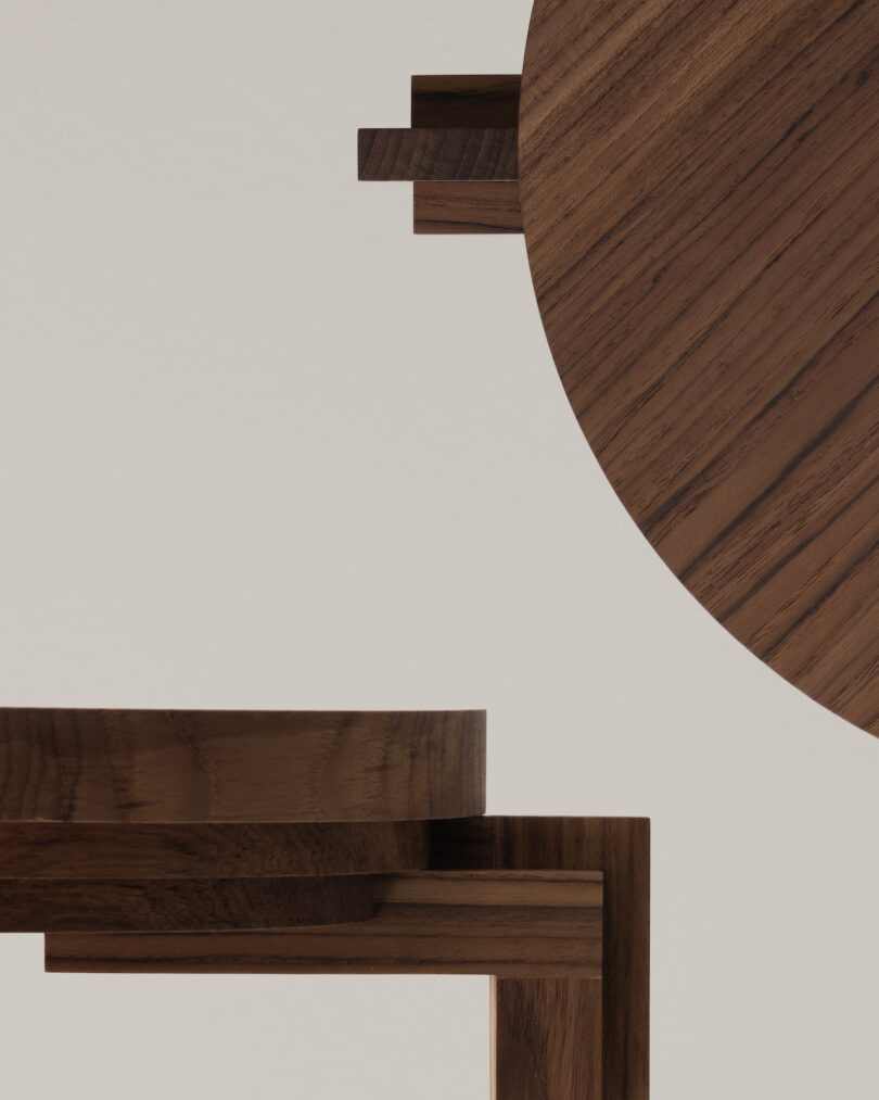 Close-up of overlapping modern wooden furniture pieces against a neutral background