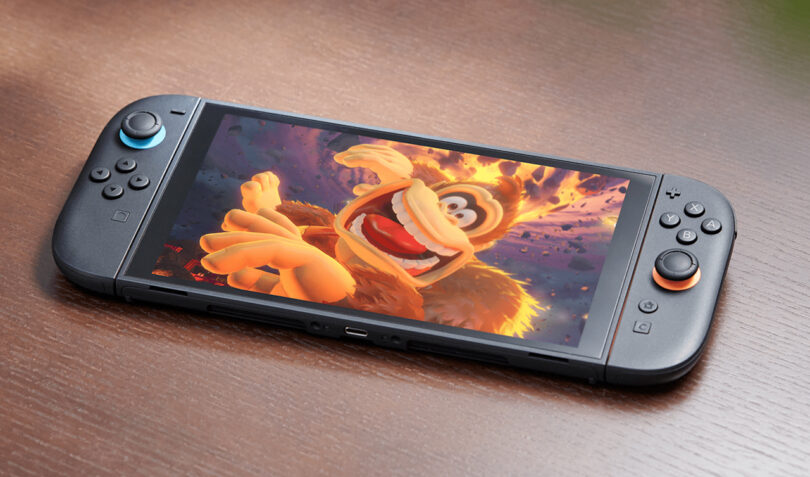 A handheld gaming console on a wooden surface displays an animated character with a fiery background on its screen.